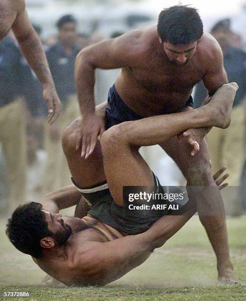 Pakistani Punjab Kabaddi wrestler Sajjad tries to capture his Indian Punjab opponent Pilwendar Singh during a Kabaddi match between Pakistan and...