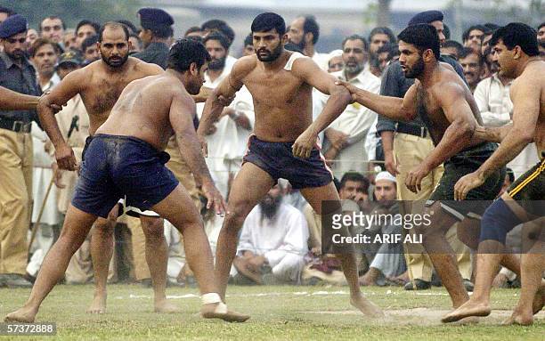 Indian Punjab Kabaddi player Lakhwinder Singh tries to touch Pakistani Punjab Kabaddi players during a Kabaddi match between Pakistan and India at...