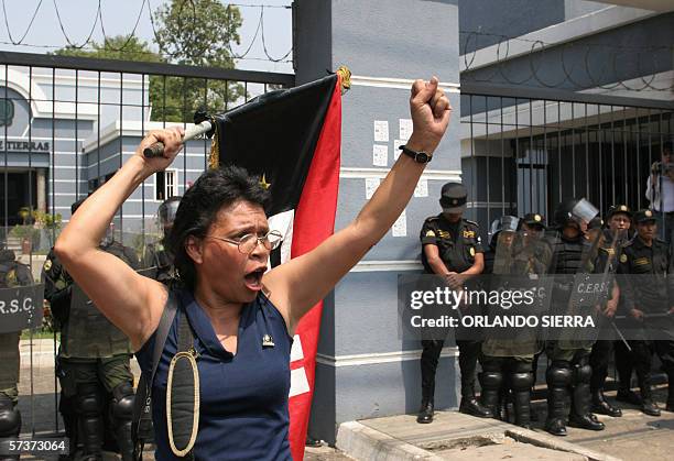Una maestra grita consignas frente a agentes antimotines de la Policia Nacional Civil al sur de Ciudad de Guatemala el 20 de abril de 2006. Miles de...