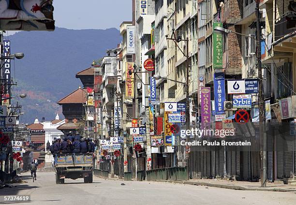 Armed police ride in a truck down a quiet street in the downtown area during an 18-hour curfew as demonstrations against the rule of King Gyanedra...