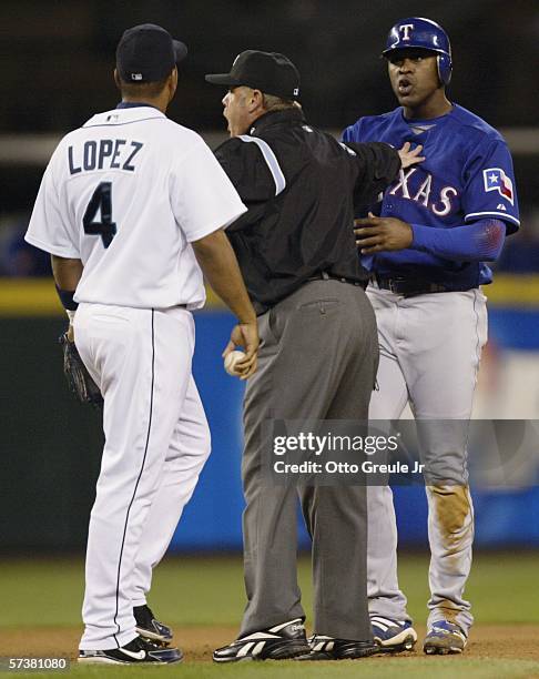 Gary Matthews of the Texas Rangers and Jose Lopez of the Seattle Mariners are separated by umpire Jim Joyce after Matthews doubled and took issue...