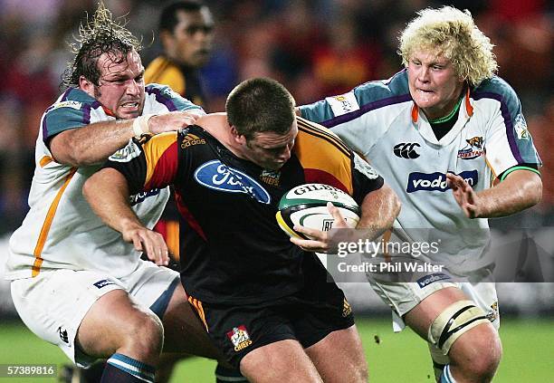 Nathan White of the Chiefs is tackled by Jannie Du Plessis and Kobus Grobbelaar of the Cheetahs during the Round 11 Super 14 match between the Chiefs...