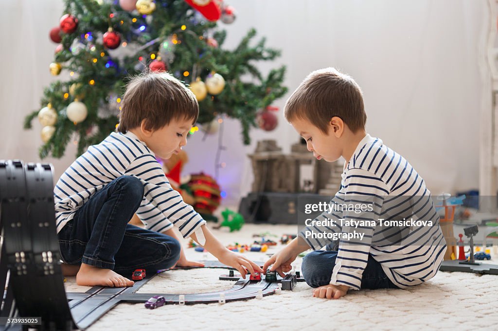 Two adorable boys, playing with toys on Christmas
