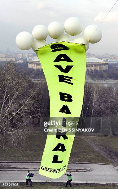 Moscow, RUSSIAN FEDERATION: Activists from the Russian branch of Greenpeace try to fly a banner during a protest against the building by Russian oil...