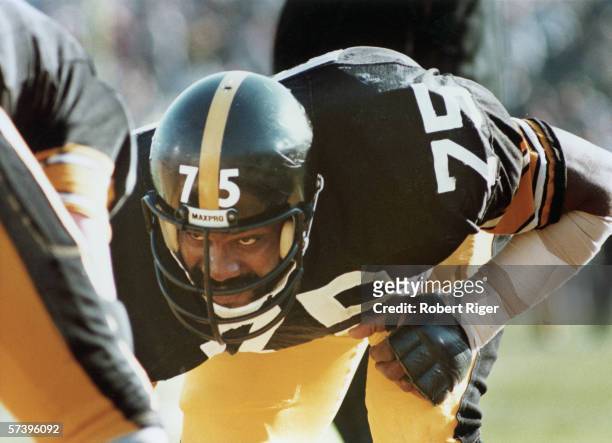 Close-up of American football player 'Mean Joe' Greene of the Pittsburgh Steelers as he crouches on the field, eyeing his opponant, 1970s.
