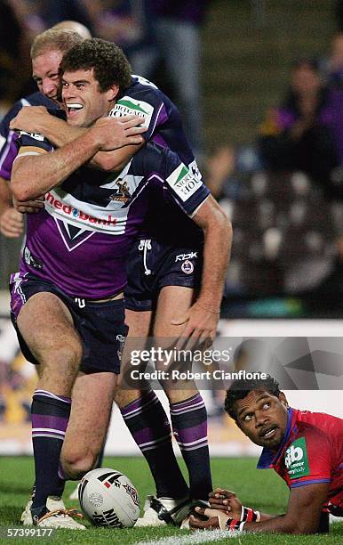 Matt King of the Storm celebrates a try as Milton Thaiday of the Knights looks on during the round seven NRL match between the Melbourne Storm and...