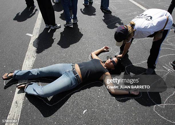 Protester lies down on the tarmac mocking to be dead during a massive rally 22 April, 2006 in Caracas. Thousands of Venezuelans marched Saturday...