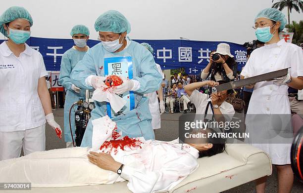 During a rally joined by thousands of Falun Gong practitiioners at Taipei 23 April 2006, four demonstrators play in an action drama against what they...