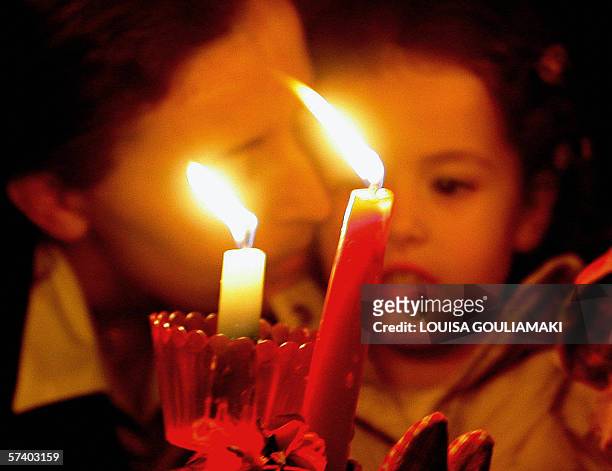 Aghi Theodori, GREECE: A woman kisses her daughter at the end of the Easter mass, while holding candles with the 'holy light,' in the village of Aghi...