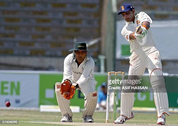 Former Indian cricket captain Mohammad Azharuddin plays a shot as Pakistani wicketkeeper Azam Khan looks on during the first One Day match of a four...