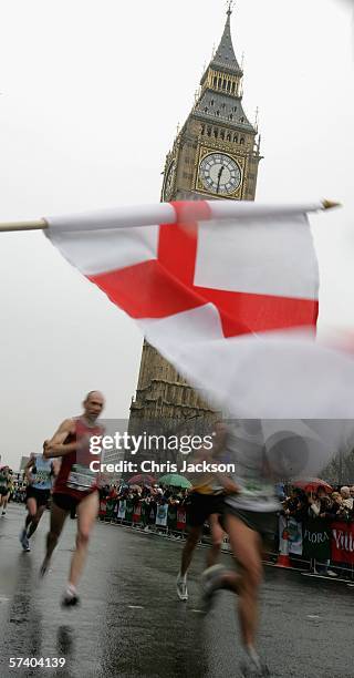 People wave St Georges flags as Competitors in the London Marathon run through Parliment Square during the London Marathon on April 23, 2006 in...