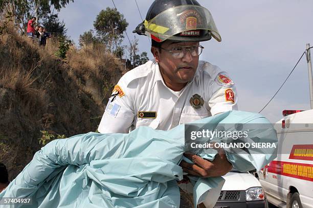 Un miembro del Cuerpo de Bomberos Voluntarios sostiene en brazos el cadaver de una nina de dos anos asesinada junto a su madre en la colonia...