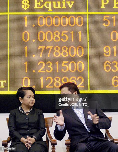 Philippine President Gloria Arroyo chats with Megaworld corporation president Andrew Tan next to a giant electronic board at the Philippine Stock...