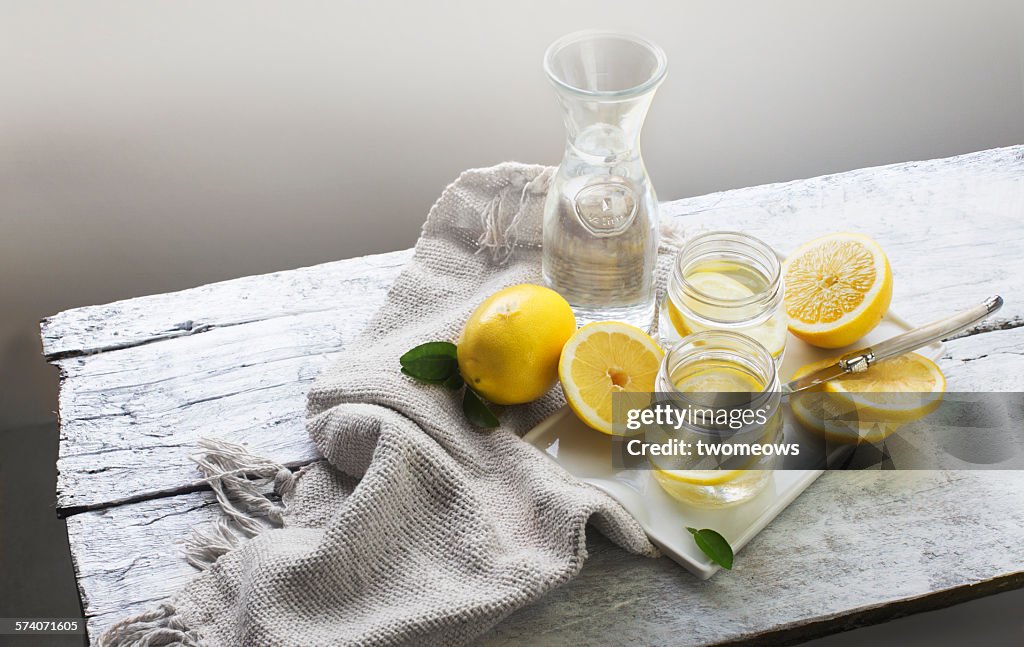 Lemon water on white wooden table. Still life.