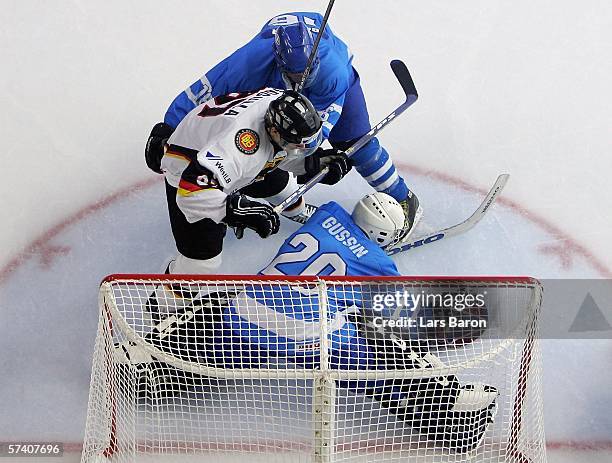 Philip Gogulla of Germany is stopped by goalie Jevgeny Gusin and Avishai Geller of Israel during the IIHF World Championship Division 1 Group A match...