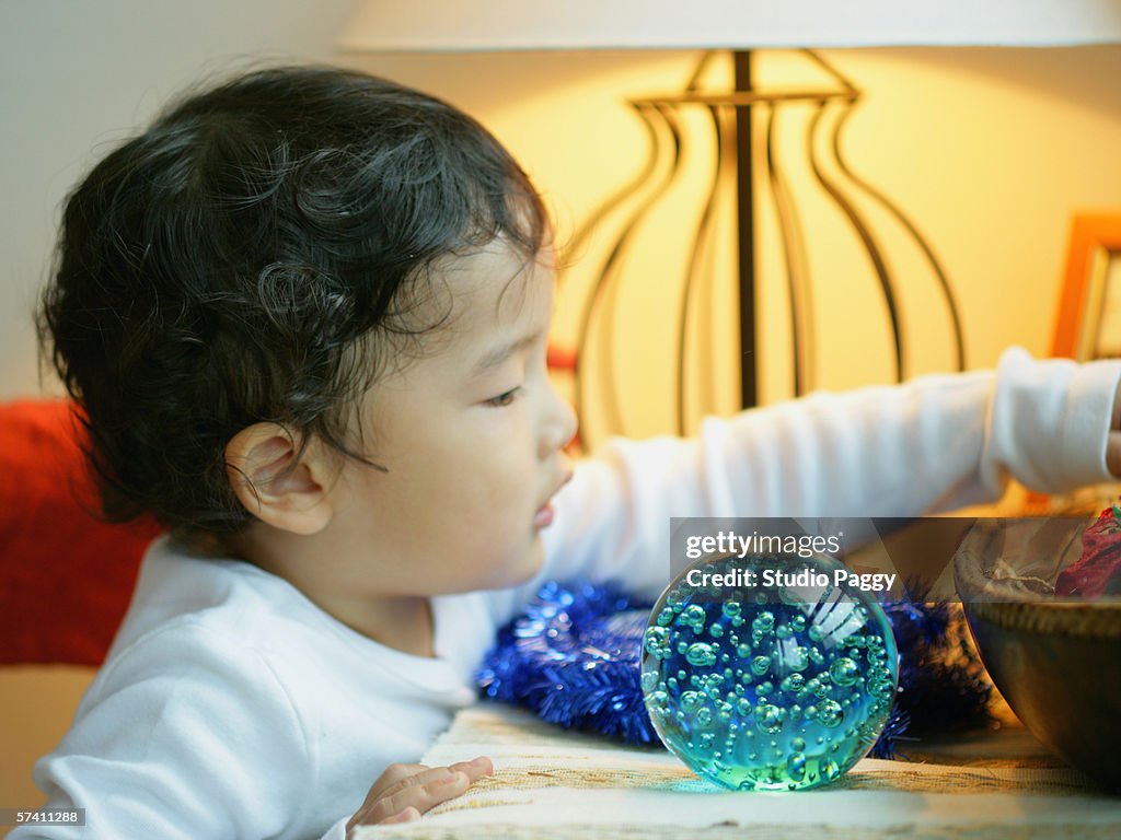 Side profile of a boy standing by a table