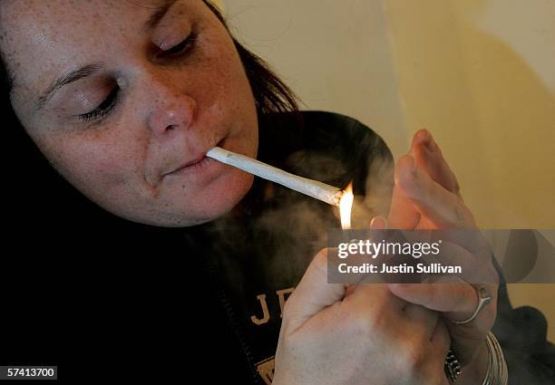 Woman lights a marijuana cigarette at the Alternative Herbal Health Services cannabis dispensary April 24, 2006 in San Francisco, California. The...