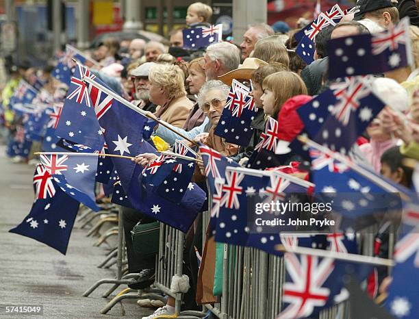 Members of the crowd wave Australian flags as they watch the Anzac Day parade April 25, 2006 in Sydney, Australia. Australians and New Zealanders...