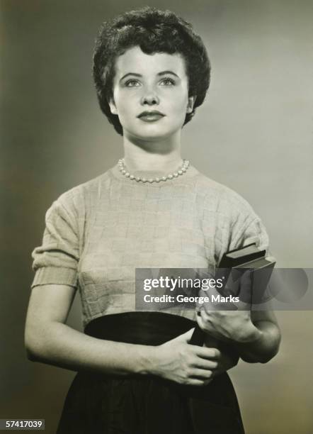 woman holding books, posing in studio, (portrait), (b&w) - 50s woman stockfoto's en -beelden