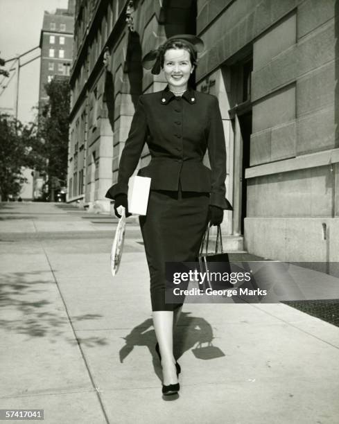 elegant woman walking on sidewalk, (b&w) - retro style shopping stock pictures, royalty-free photos & images