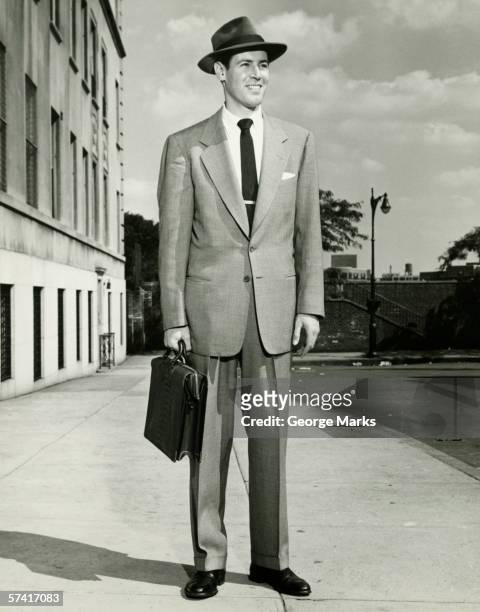 hombre en traje completo de pie en la acera, (b & p), (vertical - sombrero fedora fotografías e imágenes de stock