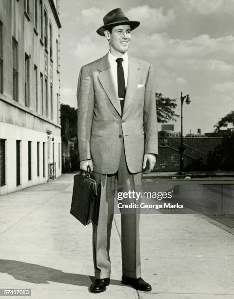 man in full suit standing on sidewalk, (b&w), (portrait) - 1930 stockfoto's en -beelden