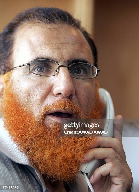 Hamas MP Mohammed Abu Teir speaks on the phone in his bureau at his home in Sur Baher, a village in the suburbs of occupied east Jerusalem 21 April...