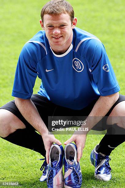 Manchester, UNITED KINGDOM: England and Manchester United soccer player Wayne Rooney holds the boots that he will wear during this summer's World Cup...