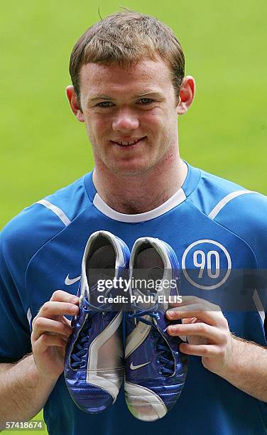 Manchester, UNITED KINGDOM: England and Manchester United soccer player Wayne Rooney holds the boots that he will wear during this summer's World Cup...