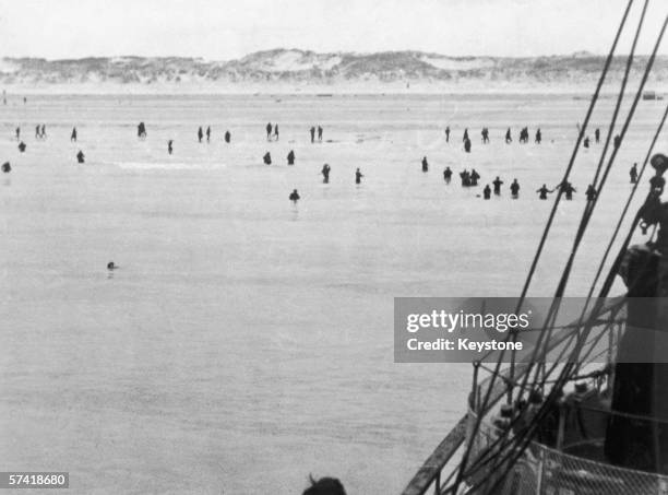 Allied troops wade out to an evacuation vessel moored off Dunkirk during World War II, 1940.