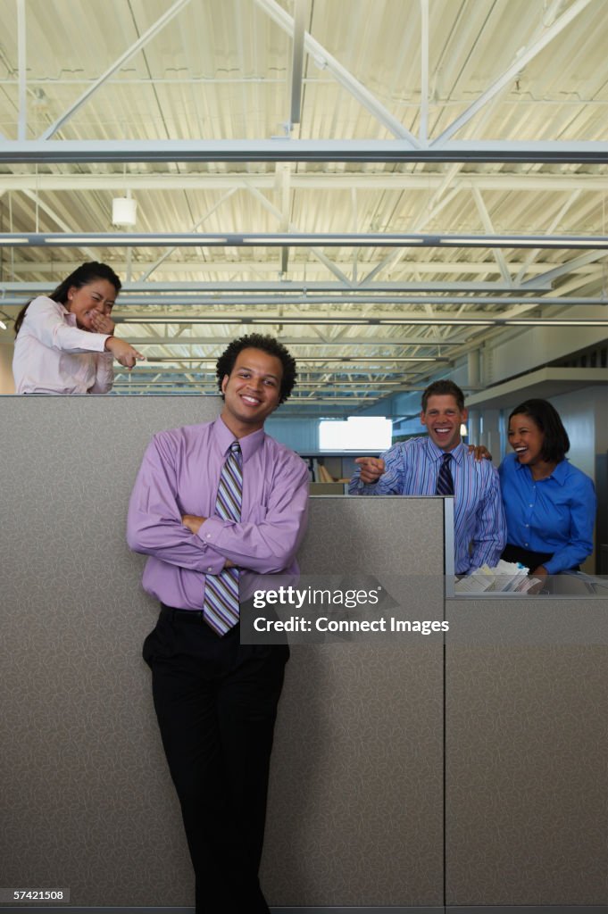 Colleagues laughing and pointing behind someone's back