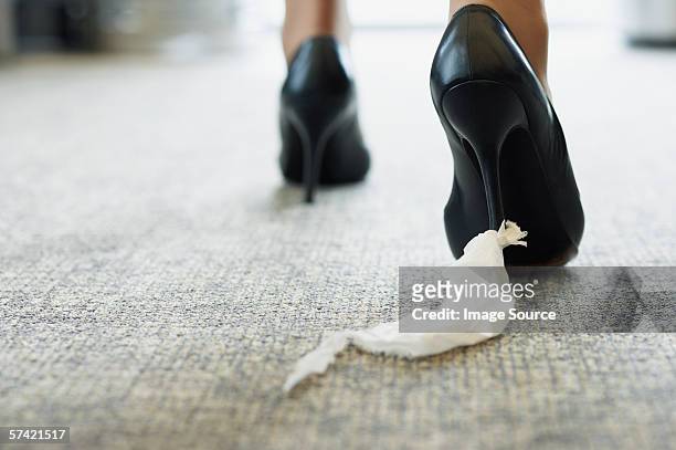 businesswoman with toilet paper stuck to her shoe - tacchi a spillo foto e immagini stock