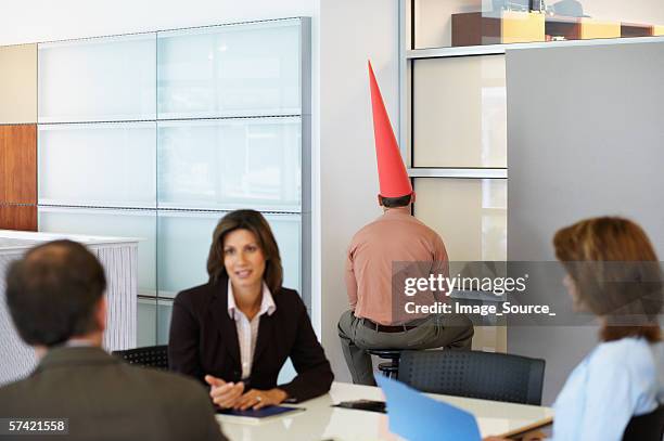 businessman sat in corner with dunce cap - dunce cap 個照片及圖片檔