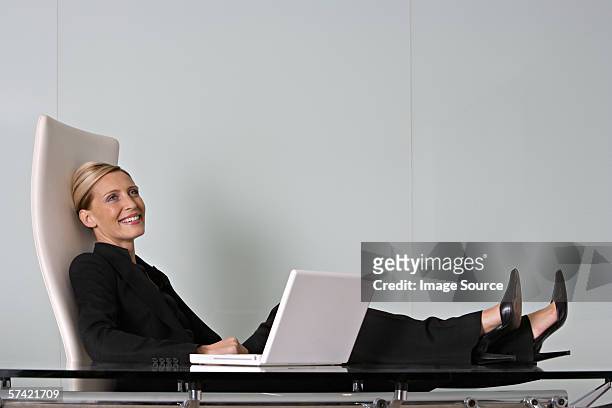 relaxed businesswoman - feet on desk stock pictures, royalty-free photos & images