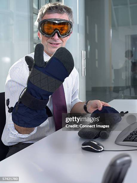 businessman wearing ski goggles and gloves - skikleidung stock-fotos und bilder