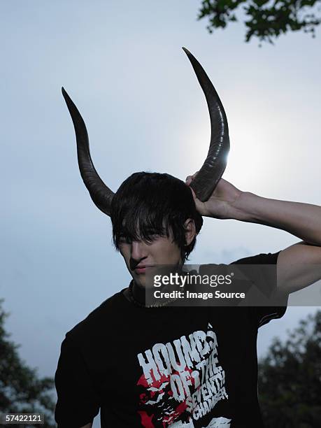 teenager boy holding tier antlers - goth boy stock-fotos und bilder