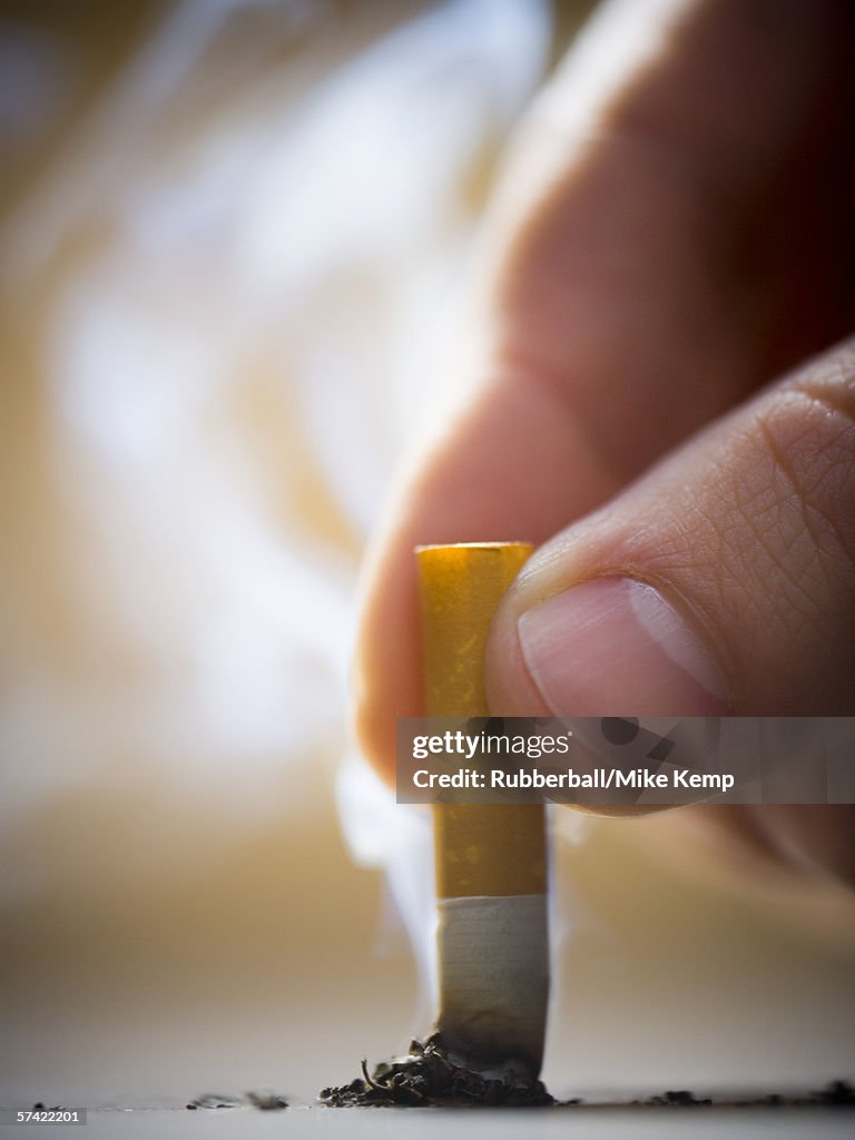 Close-up of a man putting out a cigarette