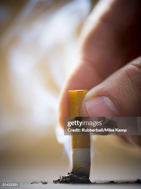 close-up of a man putting out a cigarette - rauchen aufhören stock-fotos und bilder