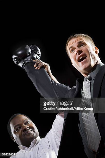 low angle view of a referee declaring the winner of a boxing match - super excited suit stock pictures, royalty-free photos & images
