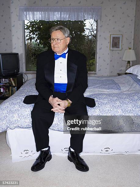 senior man in tuxedo sitting on bed - tuxedo stock pictures, royalty-free photos & images
