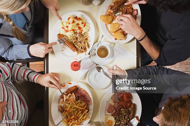 vier freunde essen im café - dinner jacket stock-fotos und bilder