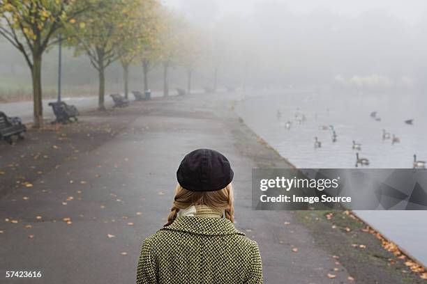 woman walking through park - fog stockfoto's en -beelden