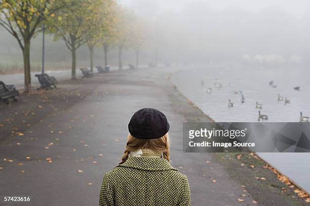 woman walking through park - fog 個照片及圖片檔
