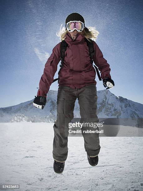 low angle view of a young woman jumping - calças para esquiar imagens e fotografias de stock