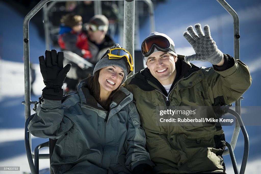 Portrait of a young couple sitting on a ski lift