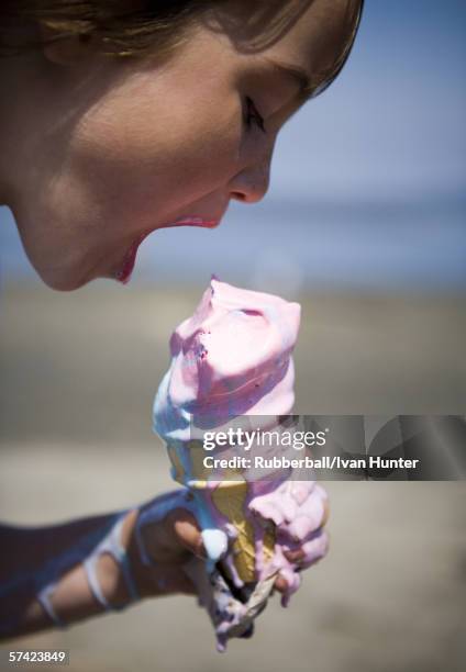 profile of a girl eating an ice-cream cone - girl eating messy ice cream cone stock-fotos und bilder