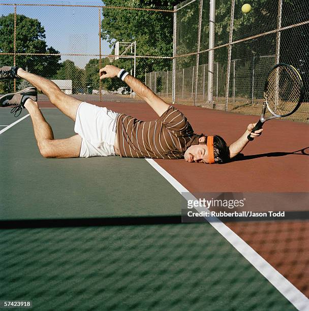 young man falling down on a tennis court - defeat funny stock pictures, royalty-free photos & images
