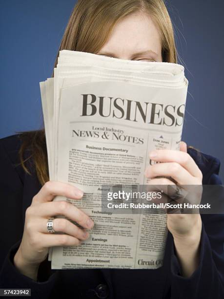 close-up of an adult woman reading a newspaper - westers schrift stockfoto's en -beelden