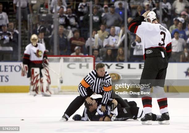 Referee Kerry Fraser protects Vincent Lecavalier of the Tampa Bay Lightning after fighting with Zdeno Chara of the Ottawa Senators as goaltender Ray...