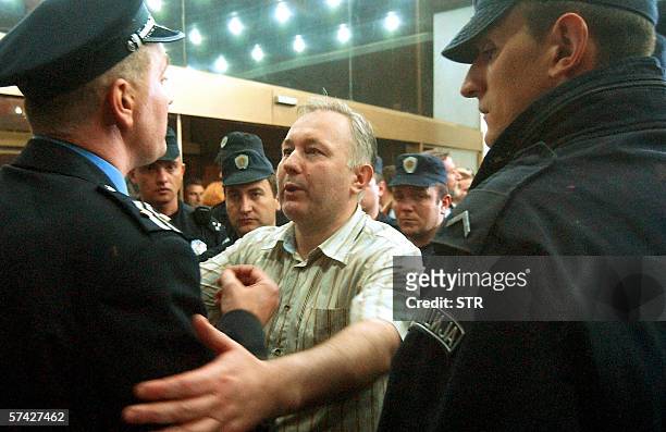 Miodrag Popov , editor in chief, talks to police officers guarding the entrance of BK television station building in Belgrade, early 26 April 2006....